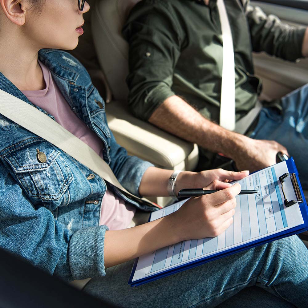 a person takes notes on a clipboard while stopped in a slough town in the uk